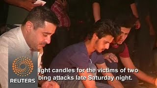 Watch Iraqis light candles for bomb victims Video